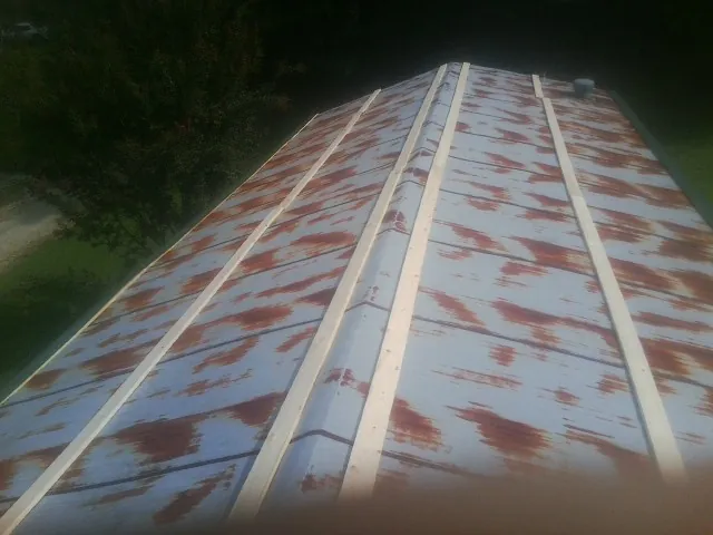 Rusted metal roof panels with new wood purlins before replacement — Storm Damage Roof Repair in Bennet by Roofing Brothers