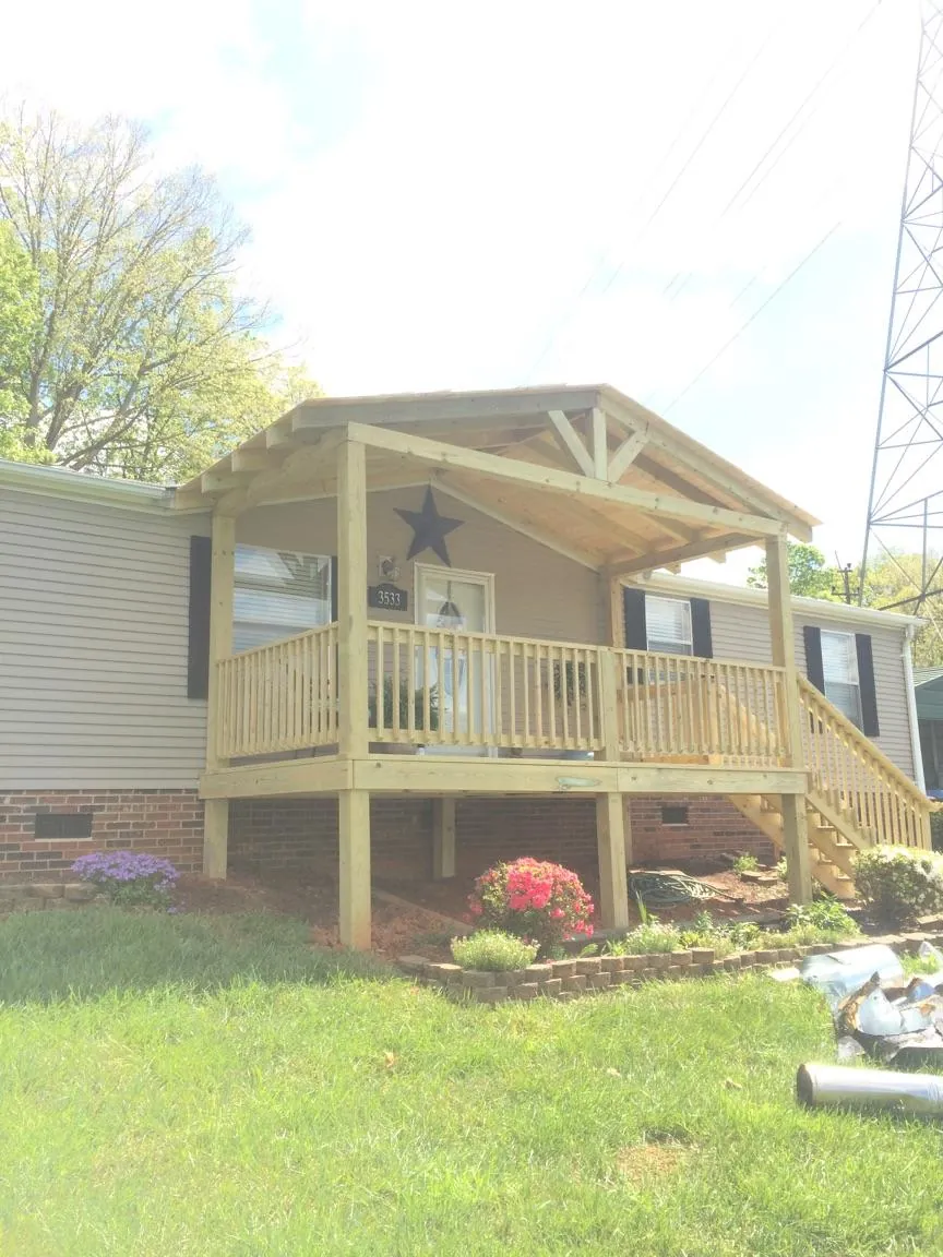 New gabled porch roof and deck railing added to a ranch home in Bennet